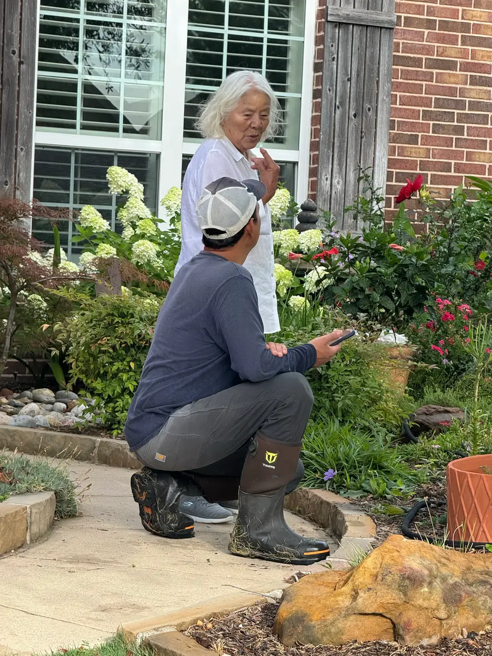 Tech consulting with homeowner about irrigation in garden